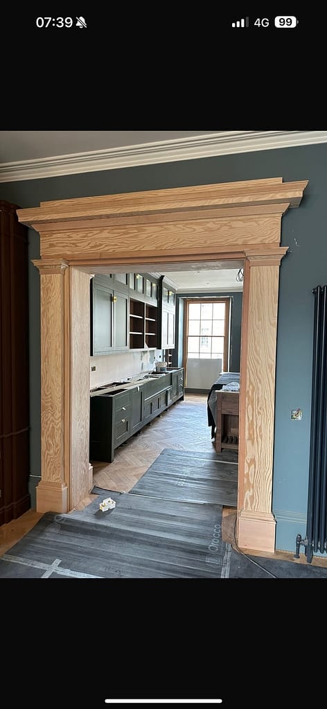 Bespoke Scottish douglas fir framing a period doorway with fitted Kitchen in a traditional Scottish home