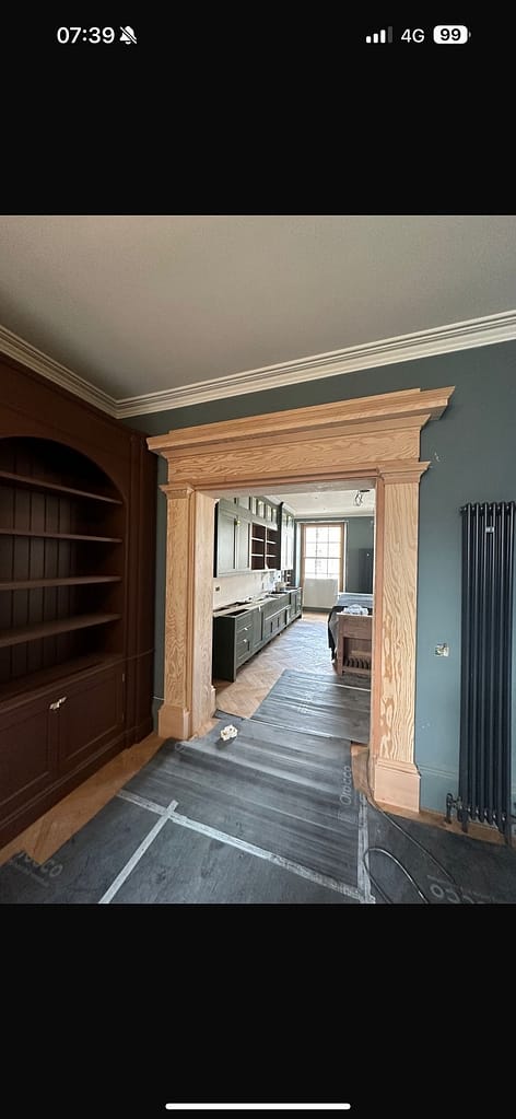 Bespoke Scottish douglas fir framing a period doorway with fitted bookcase in a traditional Scottish home