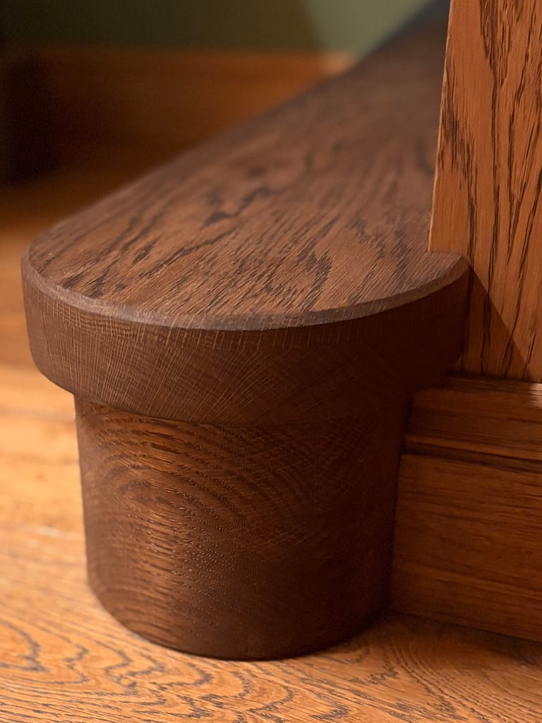 Close up of bespoke staircase newel base and rounded nosing